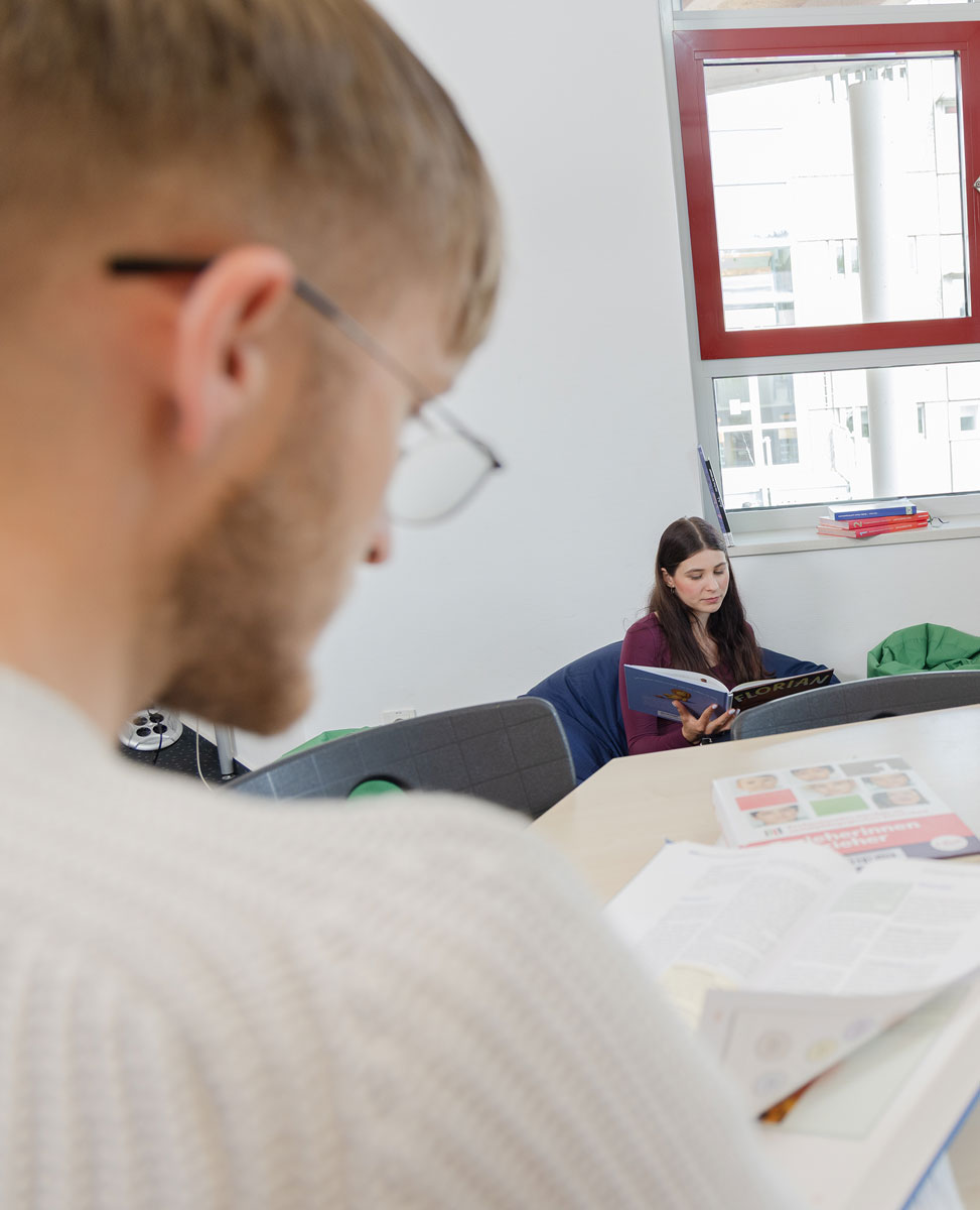 Schüler und Schülerin lesen in der Mediothek